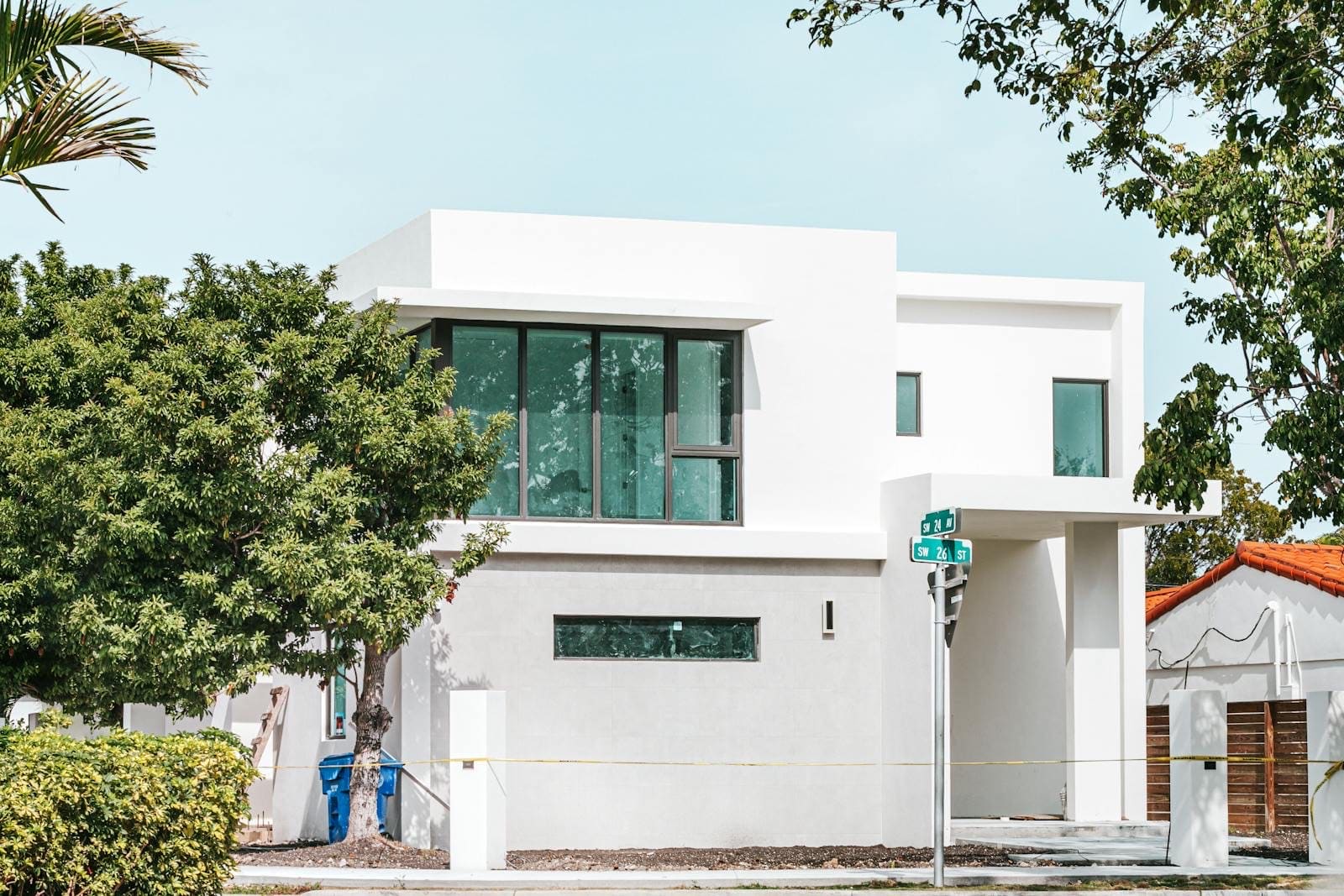 Modern white South Florida home with low-slope roof under blue sky