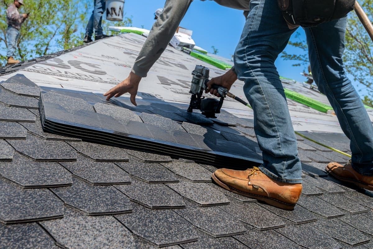 Roofer inspecting hurricane strap connections on roof deck