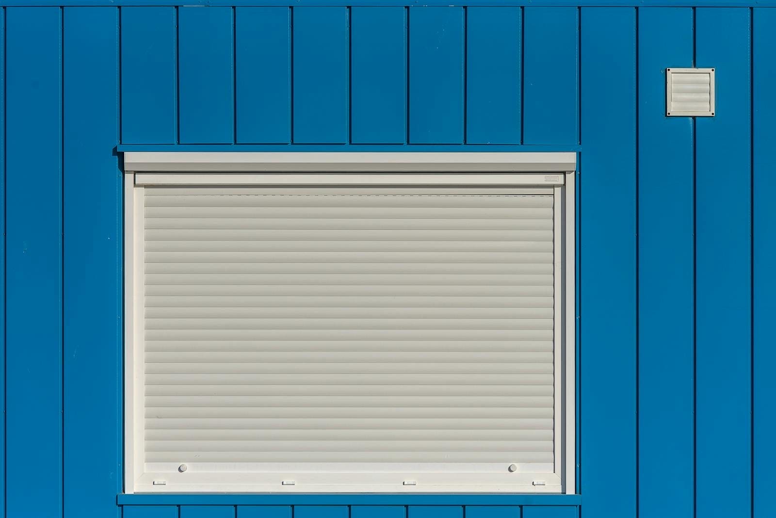 Roll-down hurricane shutters deployed over windows